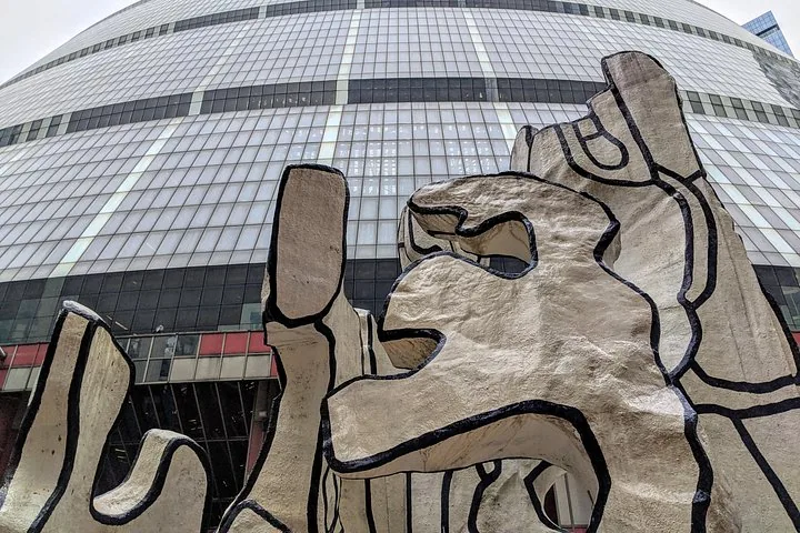 Sculpture abstraite devant un bâtiment moderne en verre